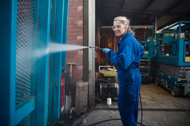 A worker is performing professional pressure washing during an industrial cleaning in Atlanta, GA